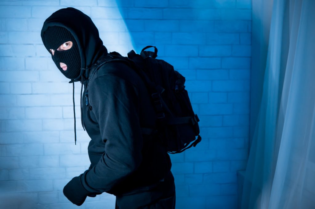 Sneaky burglar ready to steal something at home